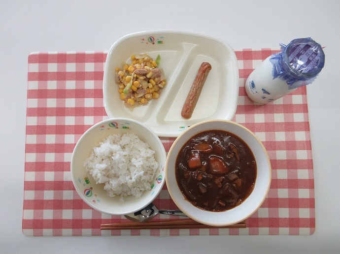 献立：麦ご飯　牛乳　ハヤシライス　焼きソーセージ　コーンサラダ