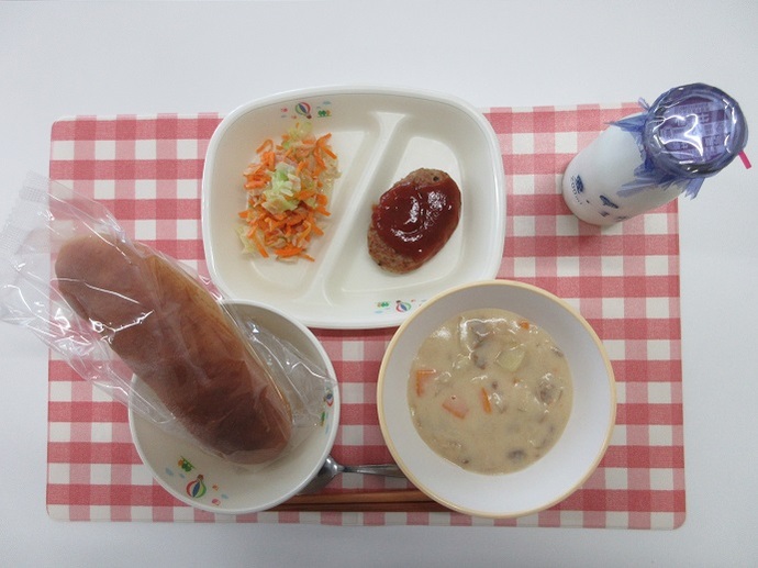 献立：くろロールパン　牛乳　クリームシチュー　ハンバーグのトマトソースかけ　にんじんサラダ