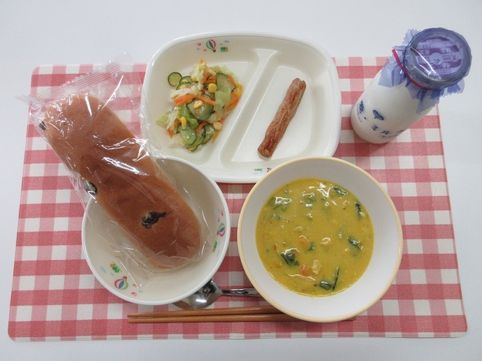 献立：レーズンロールパン　牛乳　米粉のパンプキンシチュー　焼きソーセージ　野菜のマリネ
